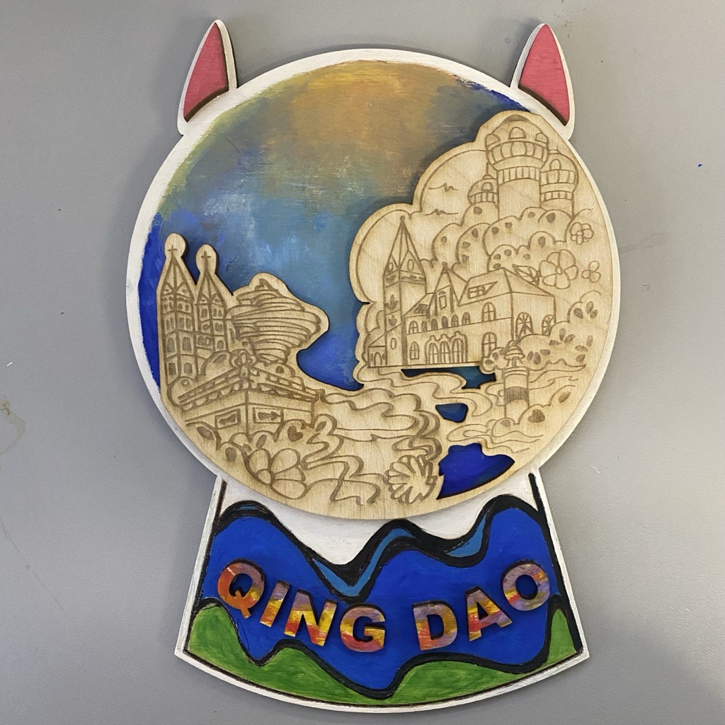 This is my final design. It's in the shape of a crystal ball, and the top layer contains five attractions from my hometown of QingDao. I colored it with watercolors. I used blue which is also the color of the sea as the background.